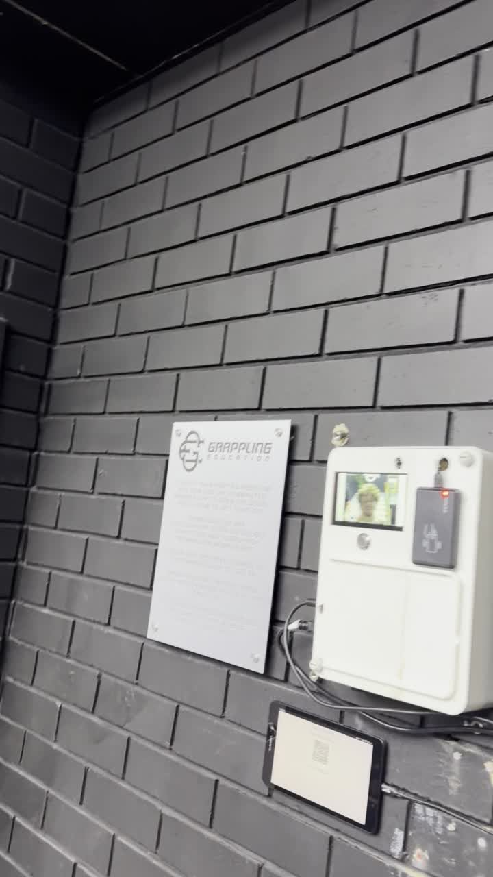 The door unit — reader, screen, and QR trial pad, on the wall.
